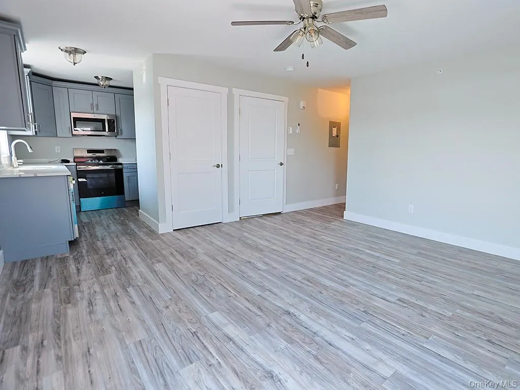 Kitchen with gray cabinetry, appliances with stainless steel finishes, light wood-style flooring, and a ceiling fan Kitchen with gray cabinetry, appliances with stainless steel finishes, light wood-style flooring, and a ceiling fan