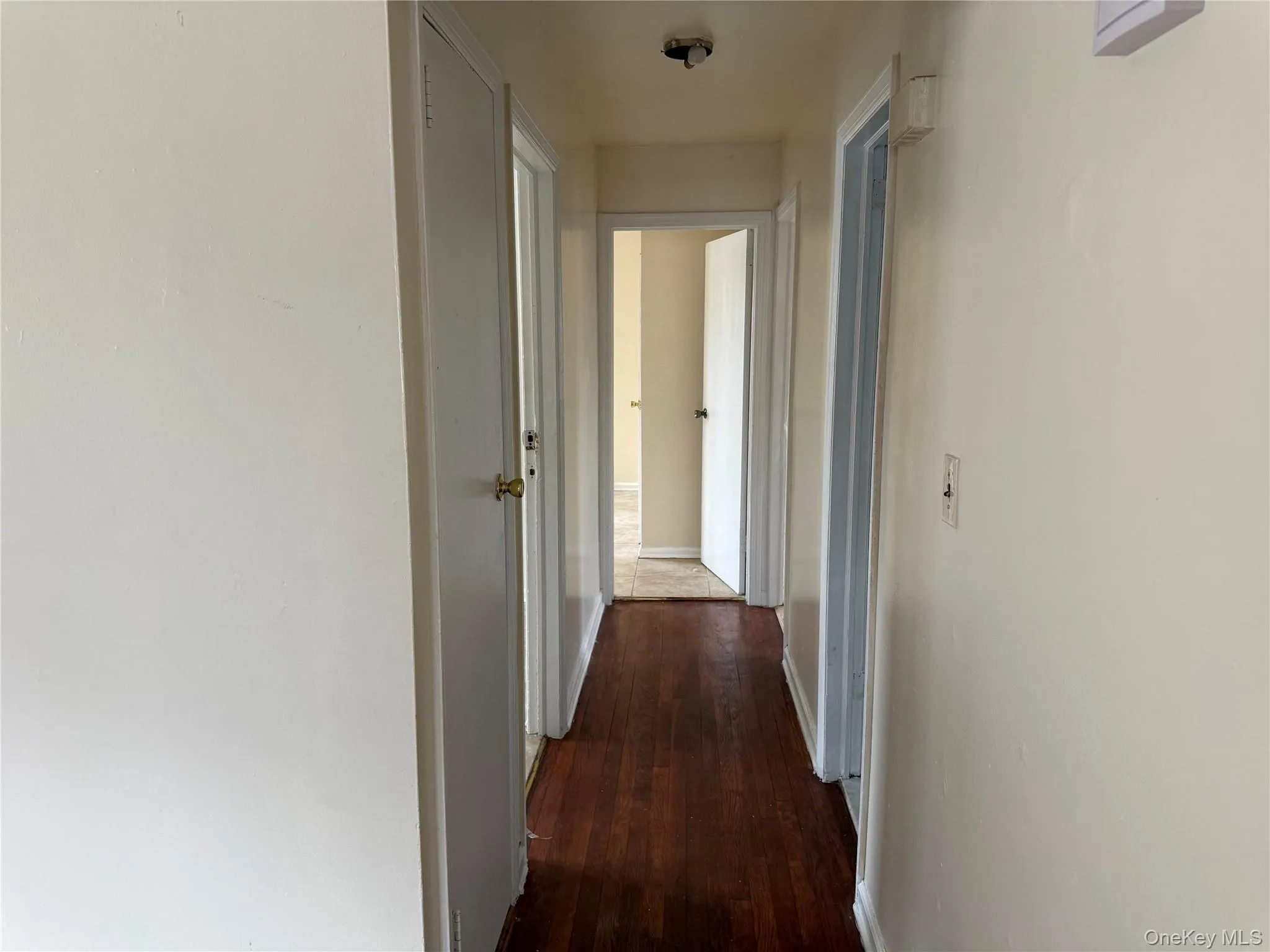 Hallway featuring dark wood-style floors and baseboards Hallway featuring dark wood-style floors and baseboards