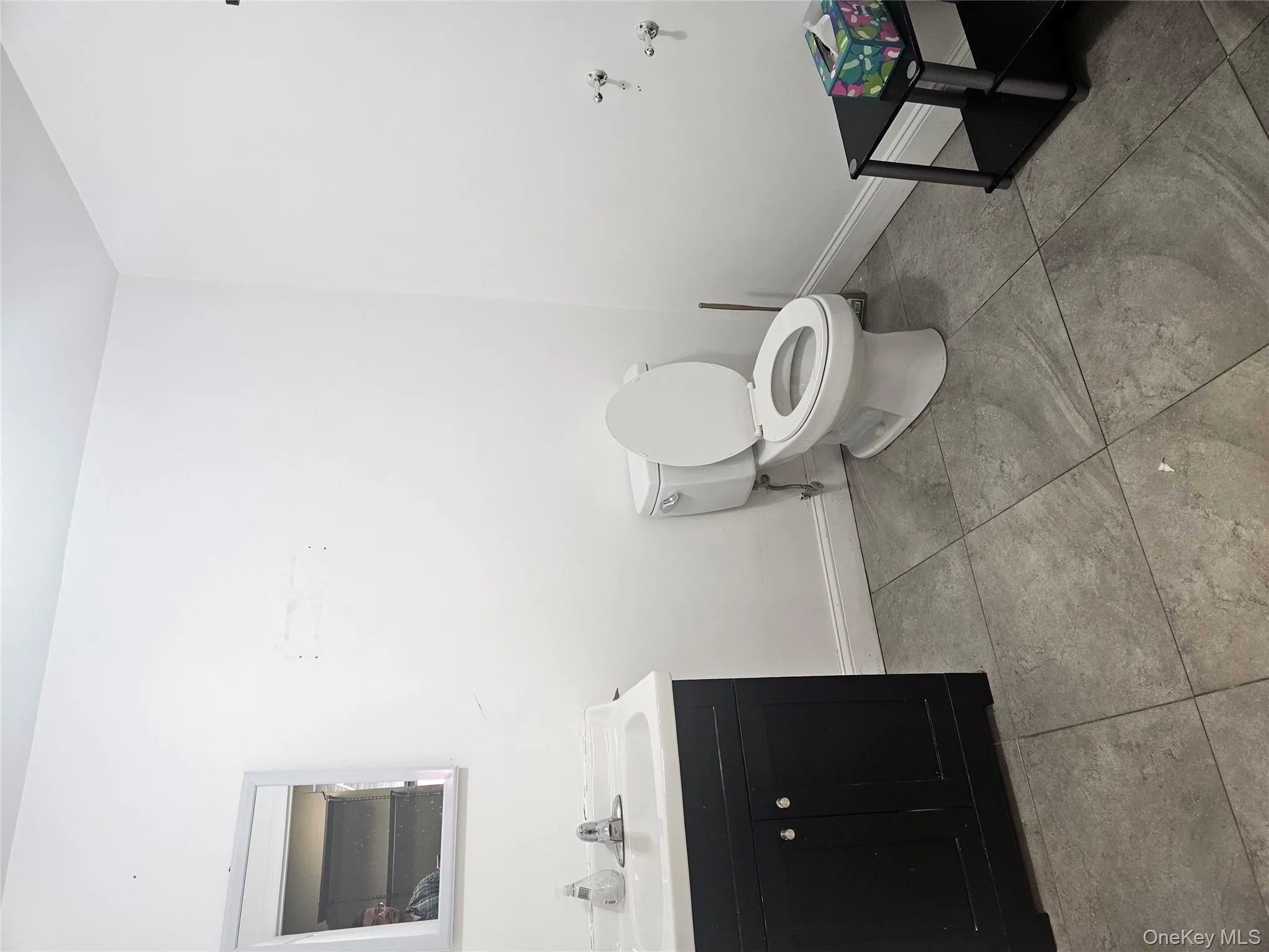 Half bath with vanity and light tile patterned flooring Half bath with vanity and light tile patterned flooring