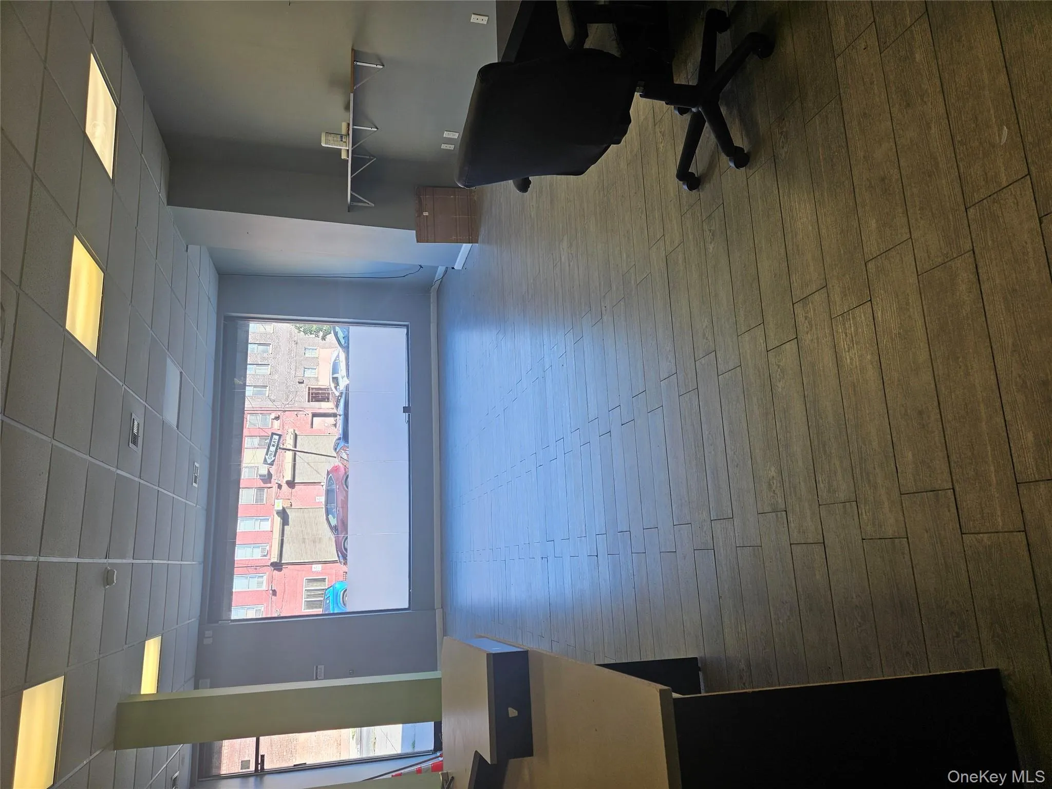 Office space featuring a drop ceiling and dark wood finished floors Office space featuring a drop ceiling and dark wood finished floors