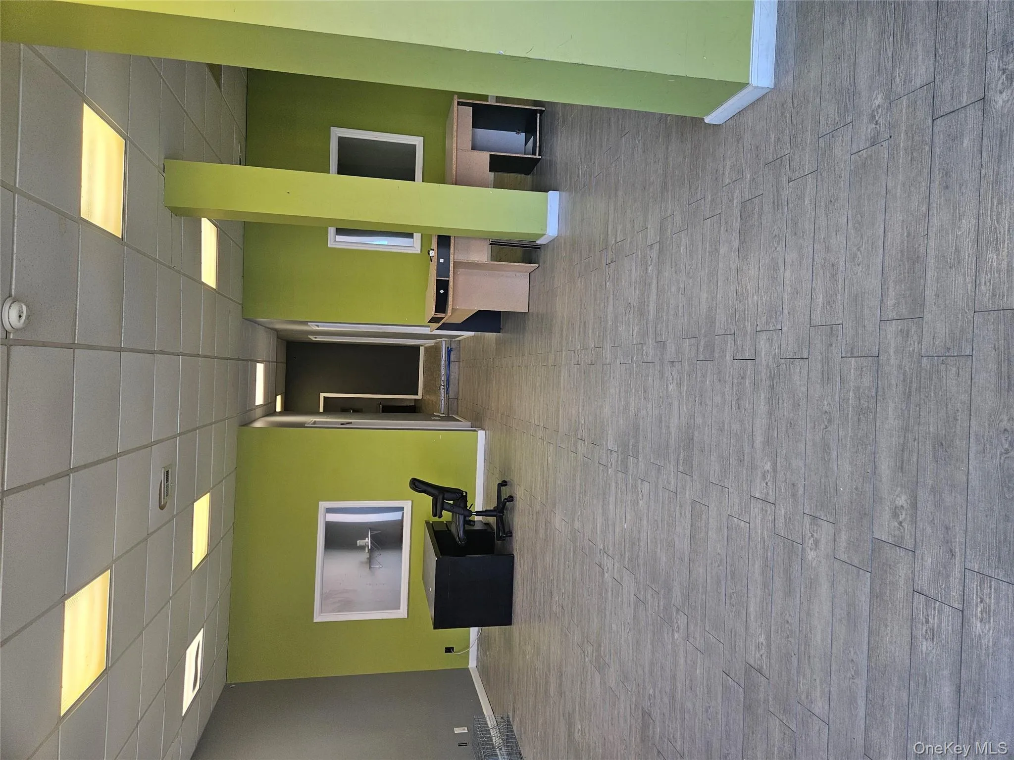 Unfurnished office with a drop ceiling and wood finished floors Unfurnished office with a drop ceiling and wood finished floors