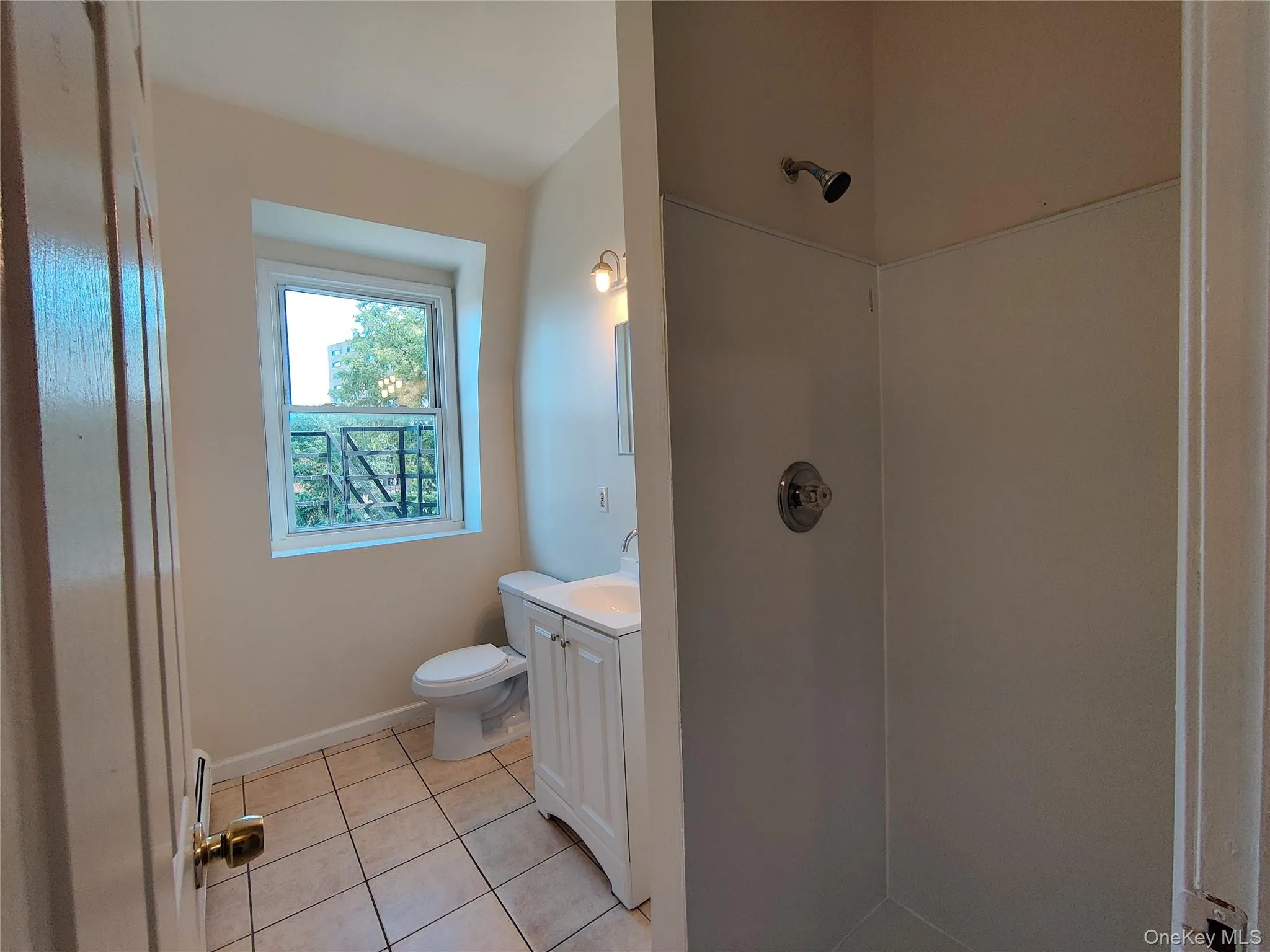 Full bath with vanity, a shower stall, and light tile patterned floors Full bath with vanity, a shower stall, and light tile patterned floors