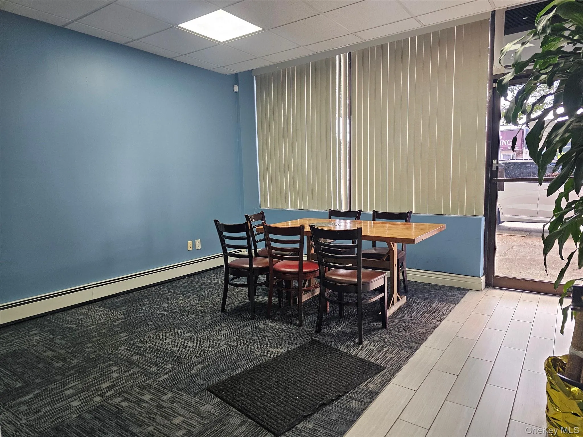 Dining room featuring a drop ceiling, a baseboard radiator, and wood finished floors Dining room featuring a drop ceiling, a baseboard radiator, and wood finished floors