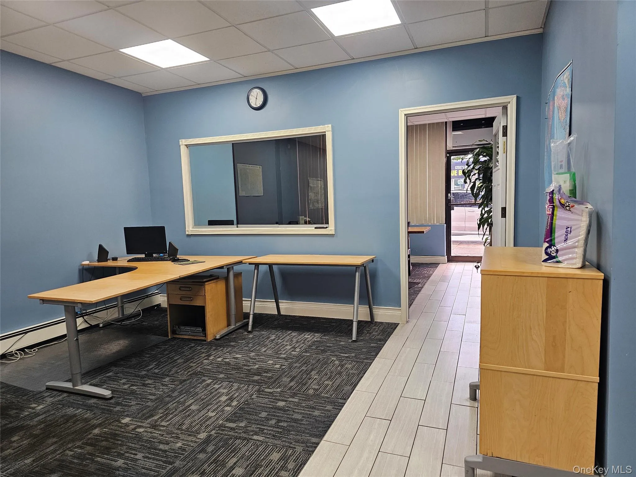 Home office with a drop ceiling, a baseboard radiator, and wood finish floors Home office with a drop ceiling, a baseboard radiator, and wood finish floors