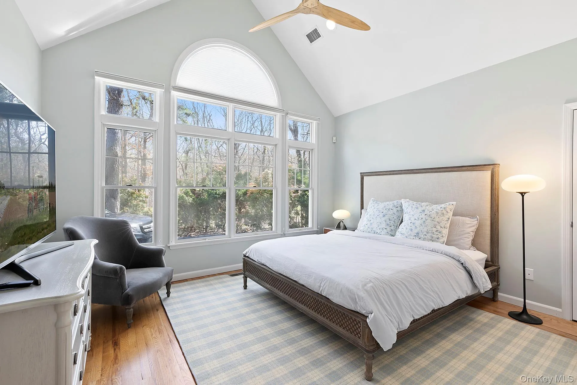 Bedroom featuring high vaulted ceiling, wood finished floors, and a ceiling fan Bedroom featuring high vaulted ceiling, wood finished floors, and a ceiling fan