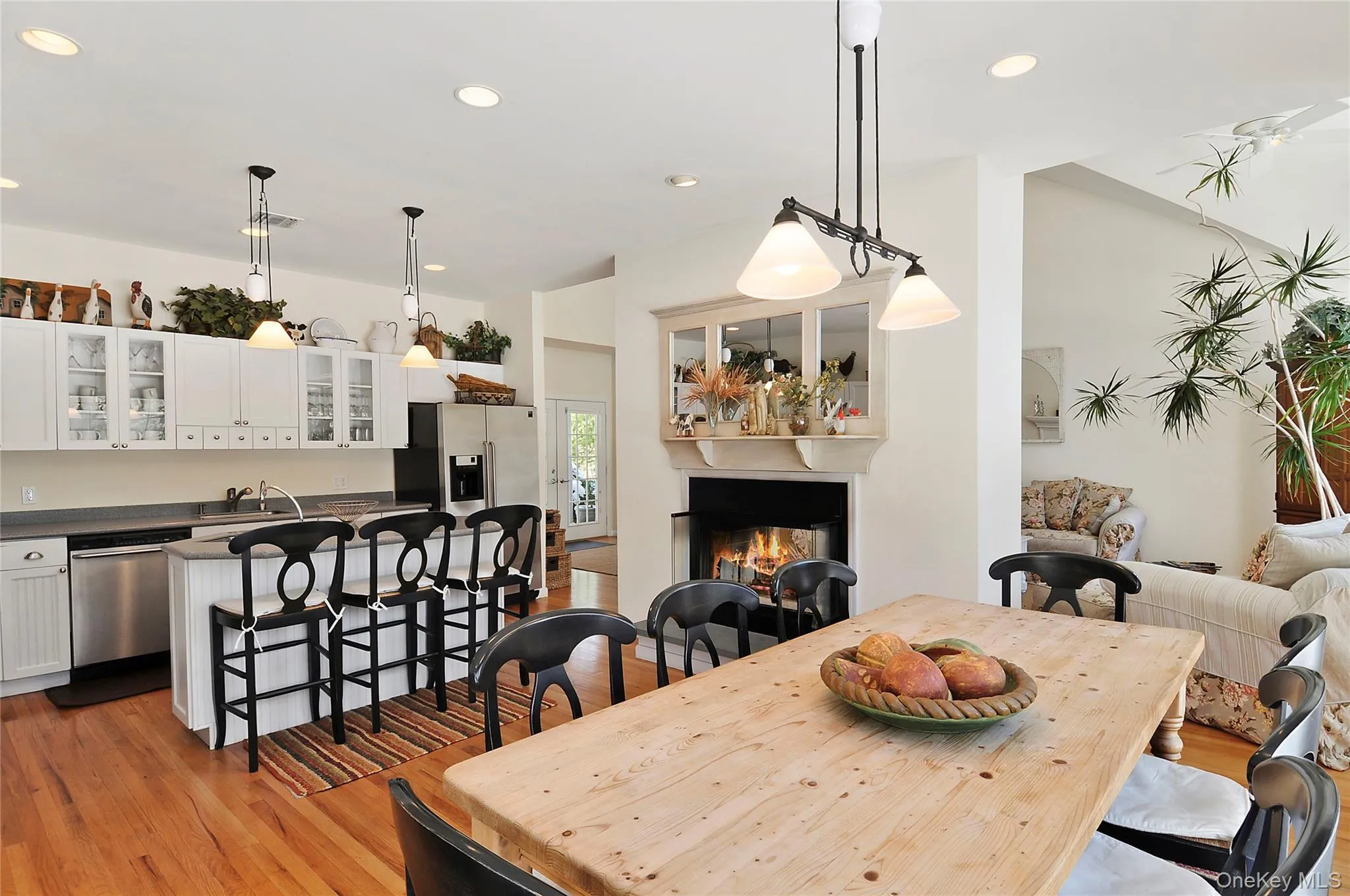 Dining room with a lit fireplace, recessed lighting, and light wood-type flooring Dining room with a lit fireplace, recessed lighting, and light wood-type flooring