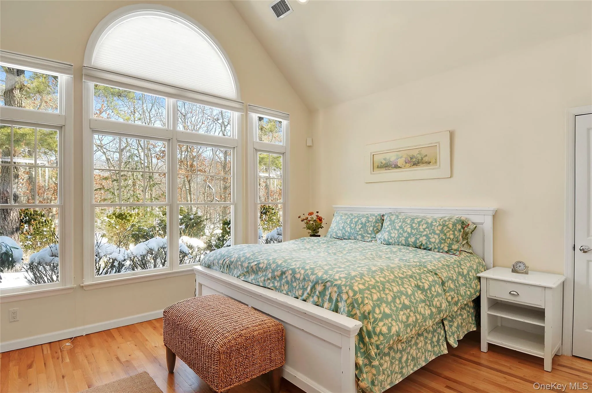 Bedroom featuring light wood-style floors and high vaulted ceiling Bedroom featuring light wood-style floors and high vaulted ceiling