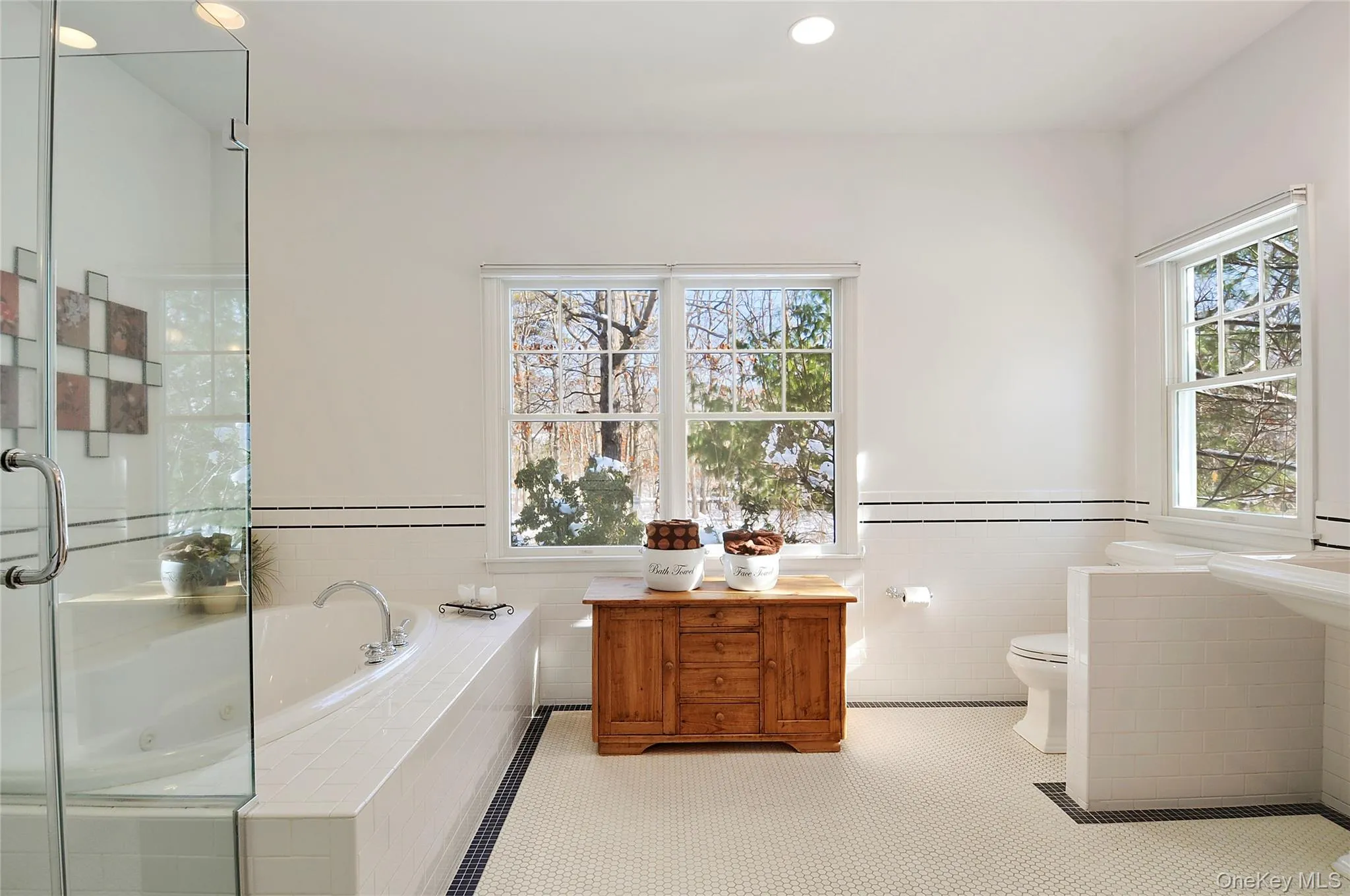 Full bathroom with a garden tub, a wainscoted wall, tile patterned flooring, a shower stall, and tile walls Full bathroom with a garden tub, a wainscoted wall, tile patterned flooring, a shower stall, and tile walls