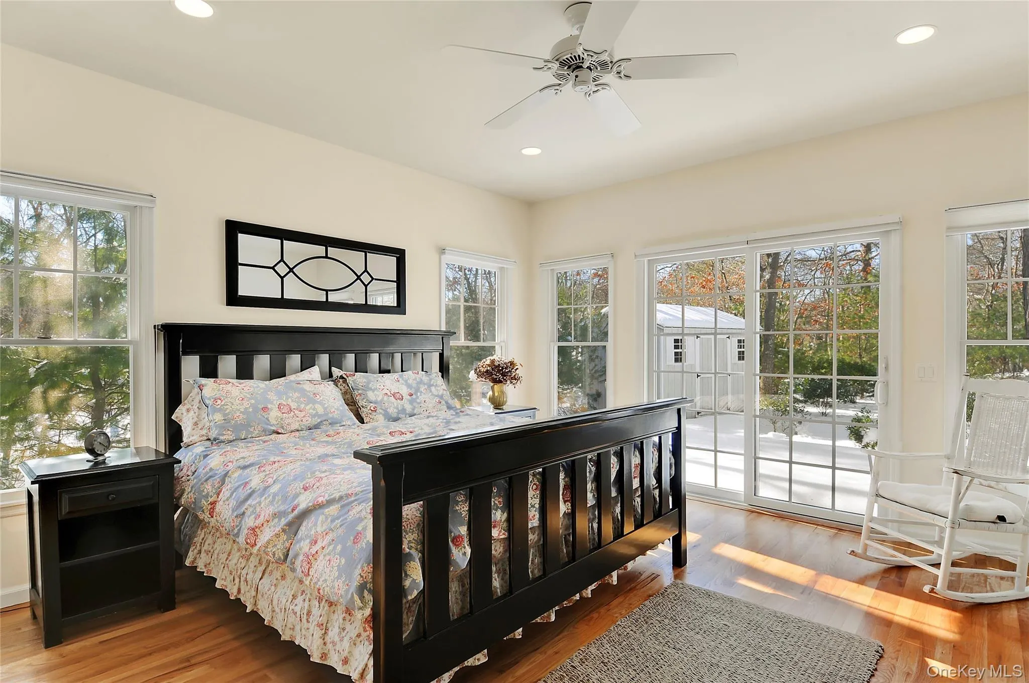 Bedroom featuring recessed lighting, light wood-style flooring, multiple windows, and access to exterior Bedroom featuring recessed lighting, light wood-style flooring, multiple windows, and access to exterior
