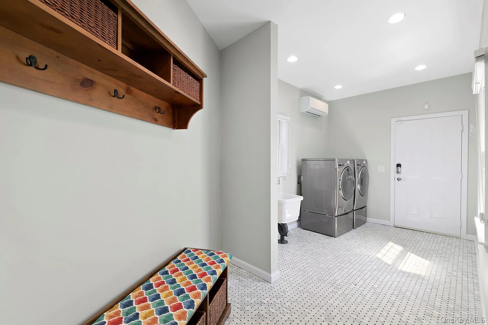 Laundry room with recessed lighting, independent washer and dryer, and a wall mounted air conditioner Laundry room with recessed lighting, independent washer and dryer, and a wall mounted air conditioner