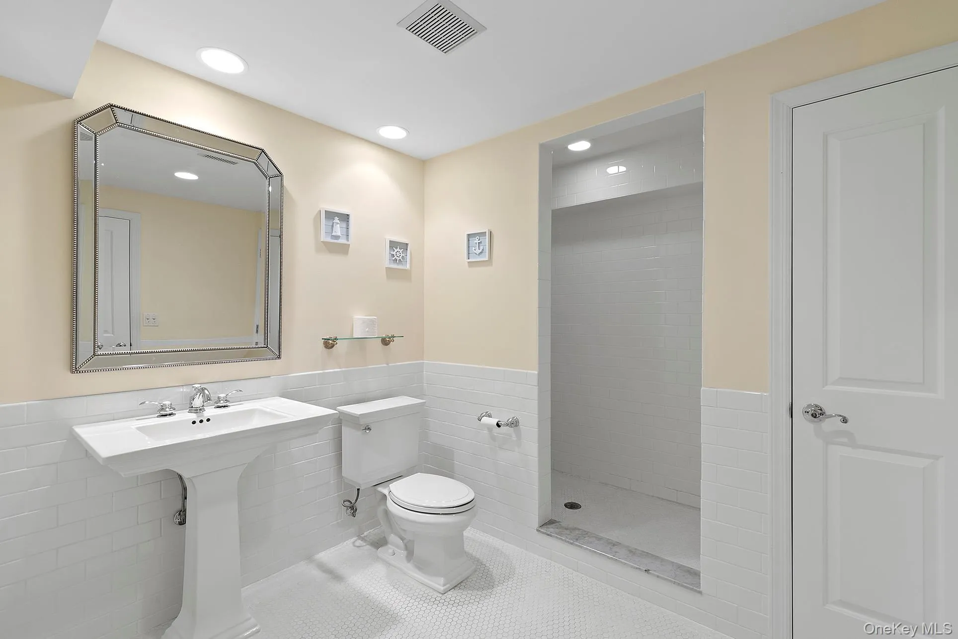 Bathroom with tile walls, a stall shower, tile patterned floors, a wainscoted wall, and recessed lighting Bathroom with tile walls, a stall shower, tile patterned floors, a wainscoted wall, and recessed lighting