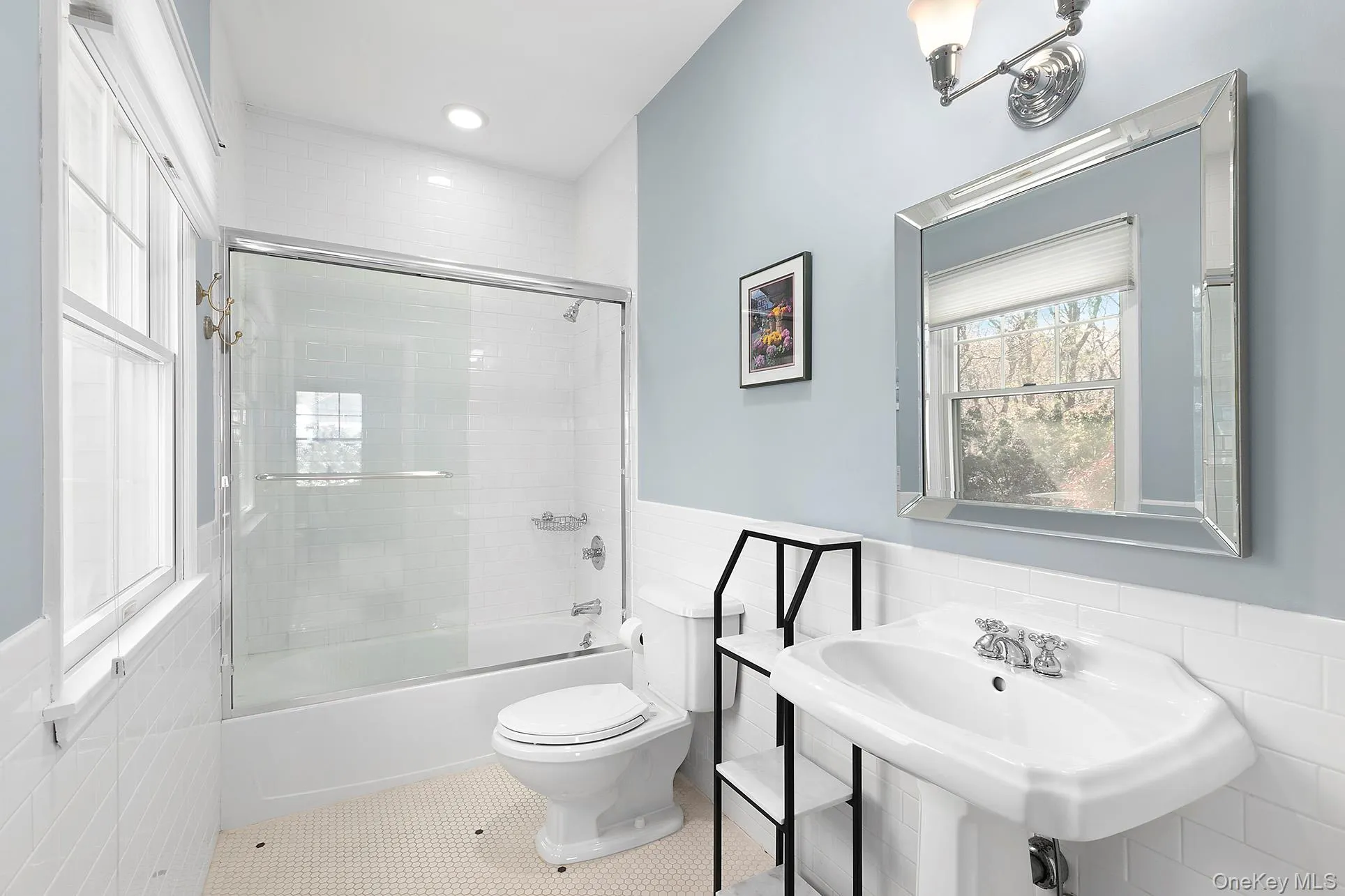 Bathroom with wainscoting, tile walls, shower / bath combination with glass door, tile patterned flooring, and recessed lighting Bathroom with wainscoting, tile walls, shower / bath combination with glass door, tile patterned flooring, and recessed lighting