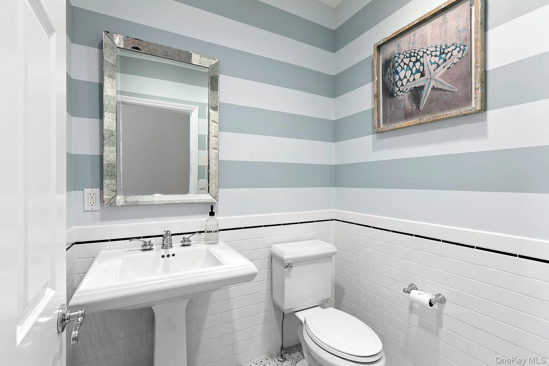 Half bath featuring tile walls and a wainscoted wall Half bath featuring tile walls and a wainscoted wall