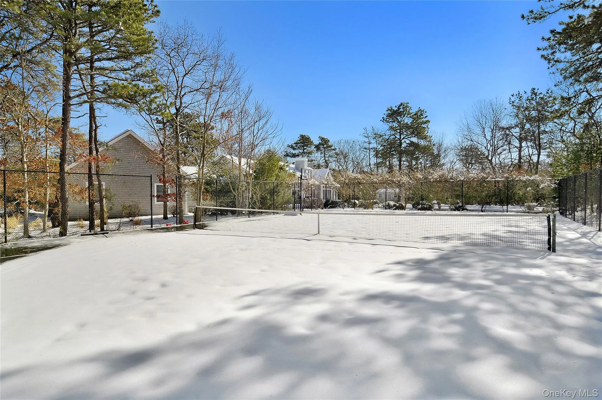Snowy yard featuring a tennis court Snowy yard featuring a tennis court
