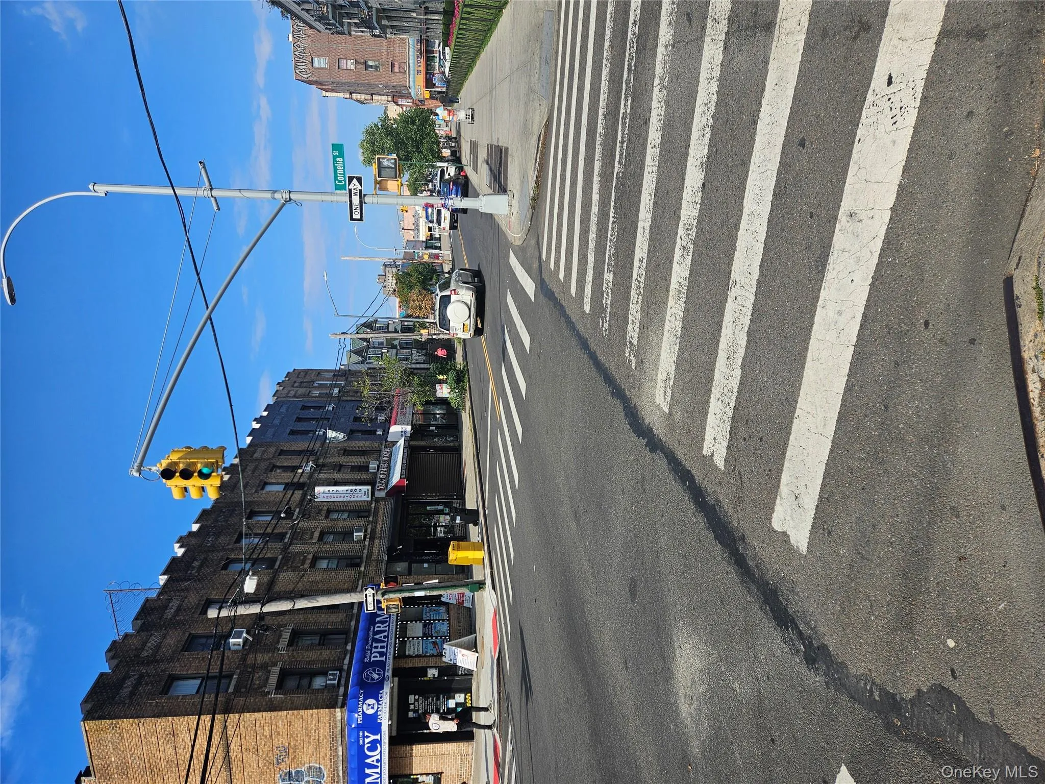 View of asphalt street with traffic lights, sidewalks, street lighting, and curbs View of asphalt street with traffic lights, sidewalks, street lighting, and curbs
