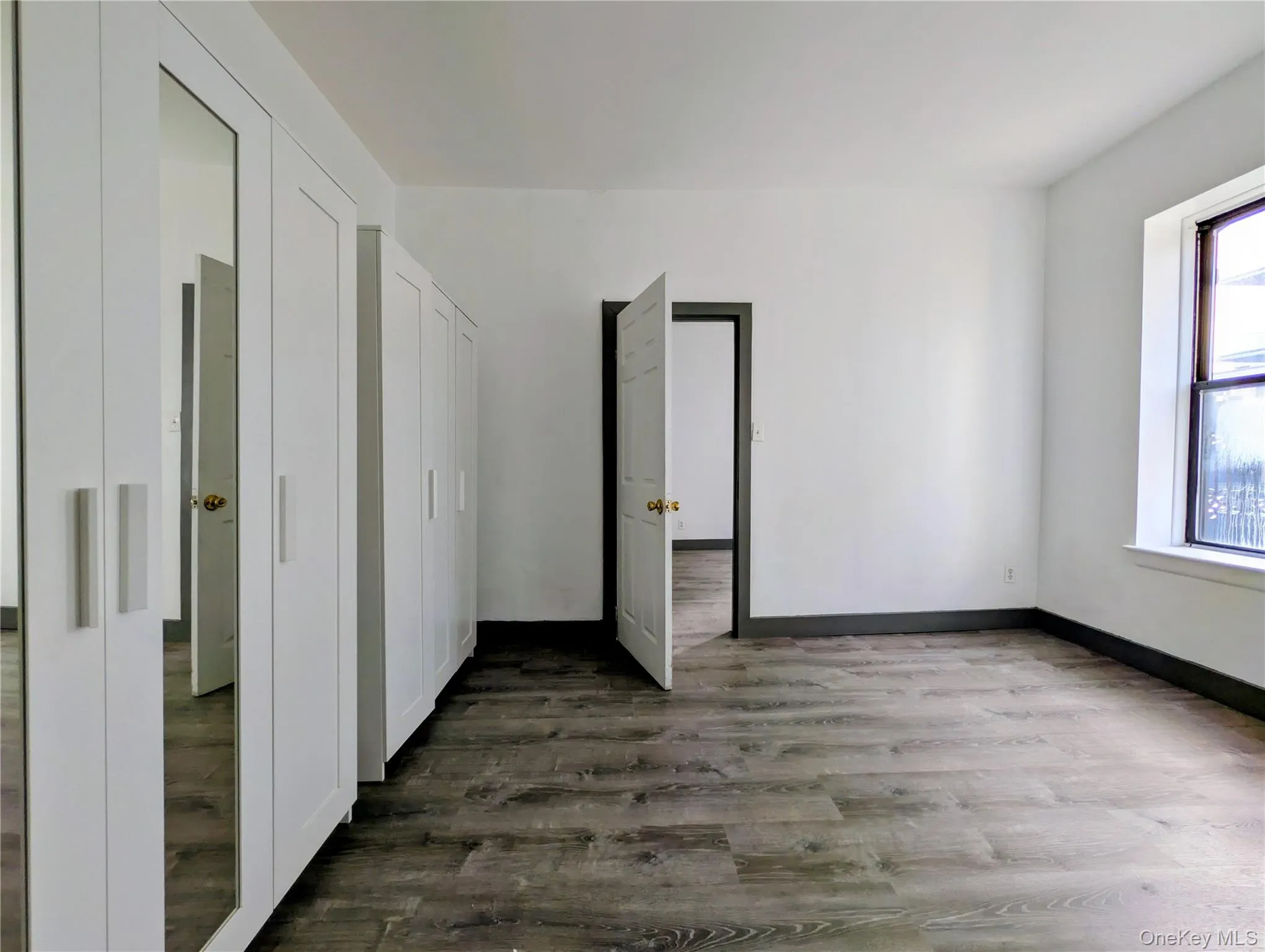 Unfurnished room featuring dark wood finished floors Unfurnished room featuring dark wood finished floors
