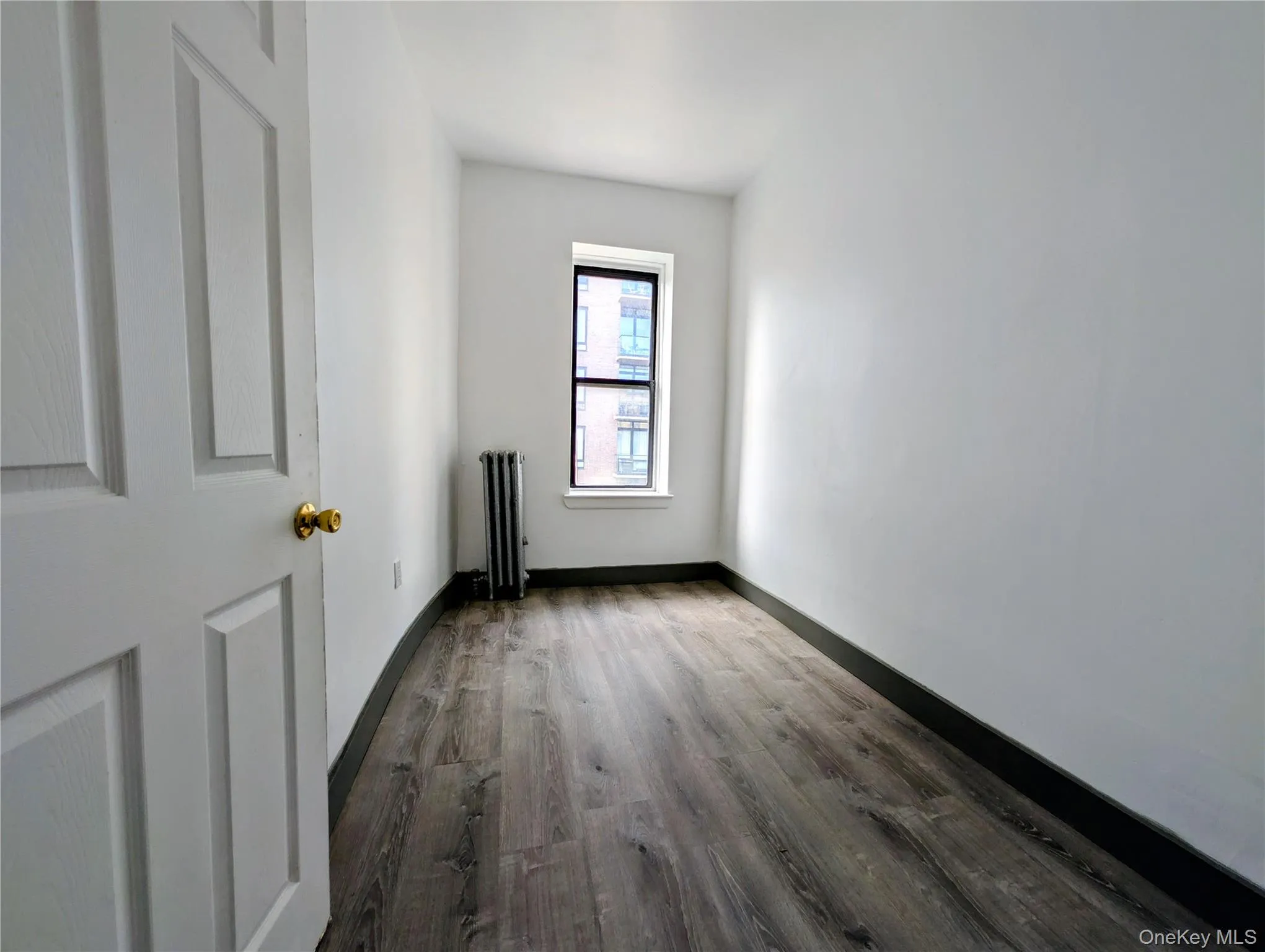 Spare room with dark wood finished floors and radiator Spare room with dark wood finished floors and radiator