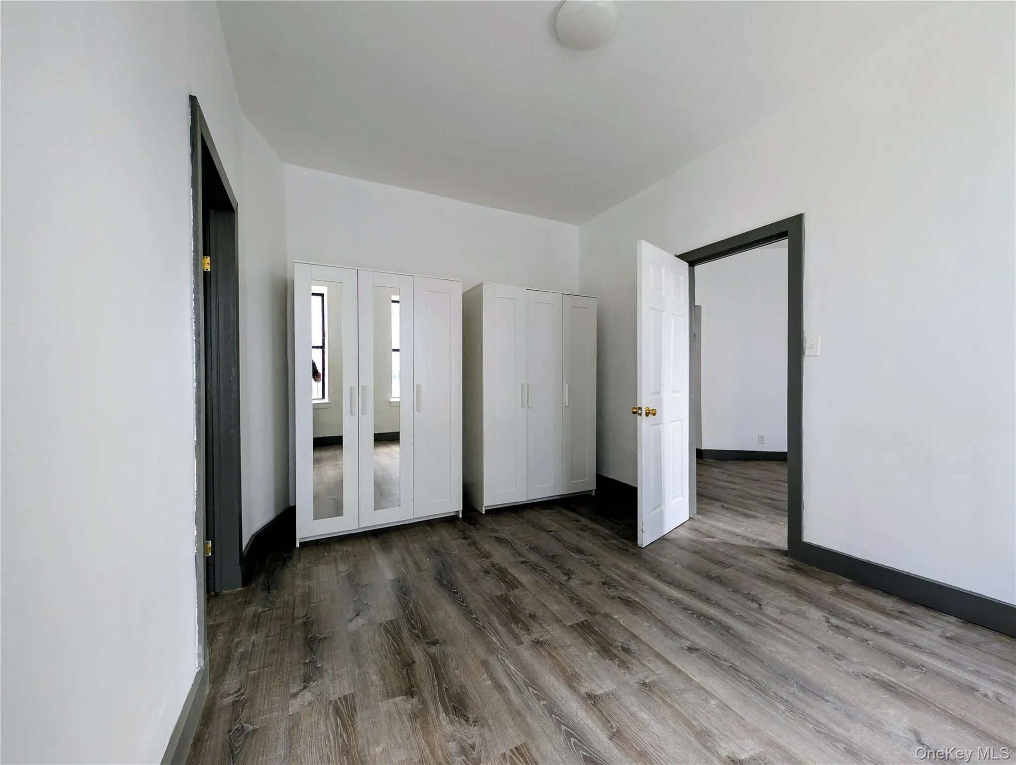Unfurnished bedroom featuring dark wood-style floors Unfurnished bedroom featuring dark wood-style floors