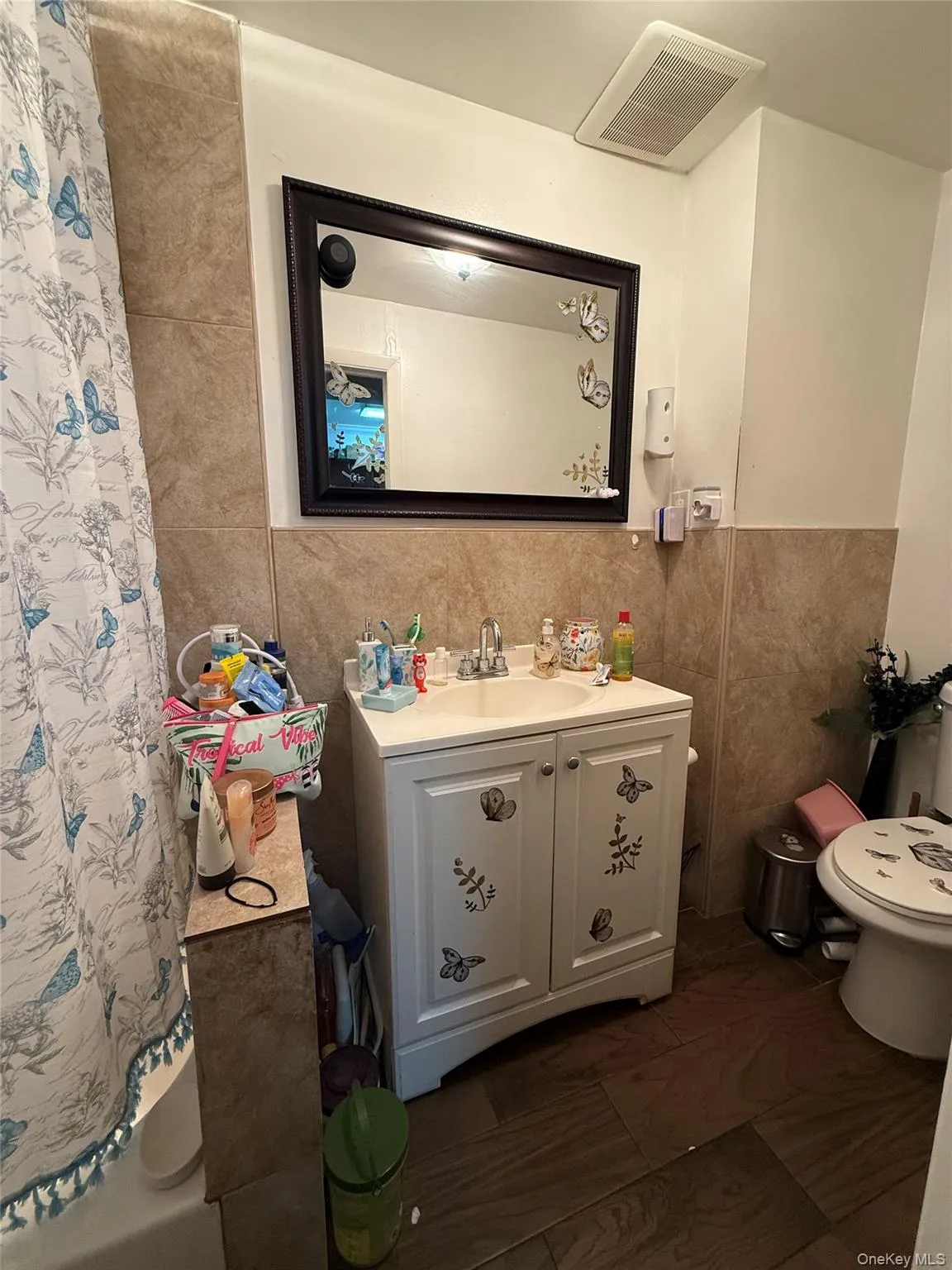 Bathroom with vanity, tile walls, and a shower with shower curtain Bathroom with vanity, tile walls, and a shower with shower curtain