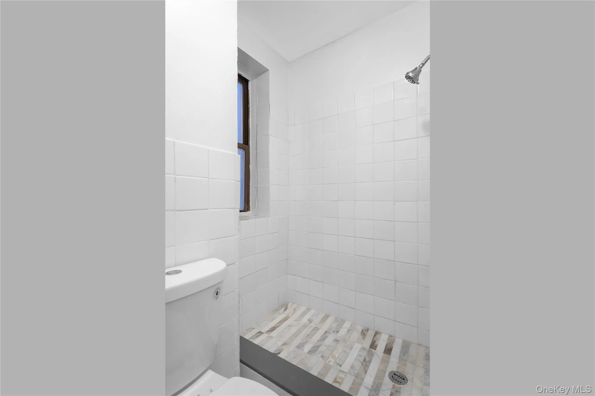Full bath featuring a shower stall and tile walls Full bath featuring a shower stall and tile walls