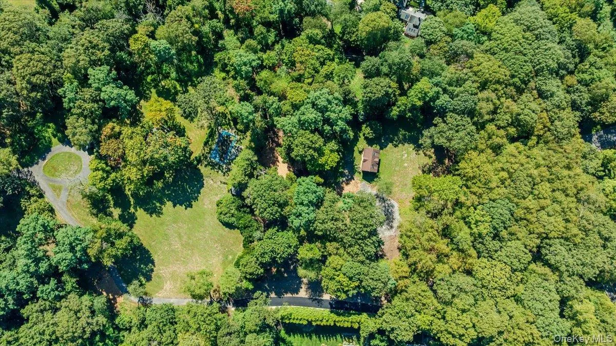 Aerial view of property and surrounding area featuring a heavily wooded area Aerial view of property and surrounding area featuring a heavily wooded area