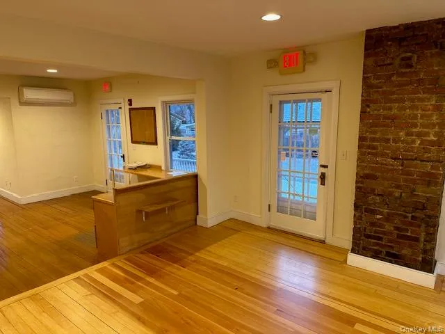 Doorway to outside featuring wood-type flooring, recessed lighting, and a wall mounted air conditioner Doorway to outside featuring wood-type flooring, recessed lighting, and a wall mounted air conditioner
