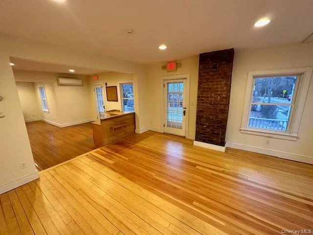 Spare room featuring light wood-type flooring, recessed lighting, and a wall mounted air conditioner Spare room featuring light wood-type flooring, recessed lighting, and a wall mounted air conditioner
