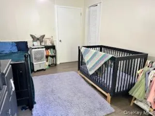 Bedroom featuring a crib and light wood-type flooring Bedroom featuring a crib and light wood-type flooring
