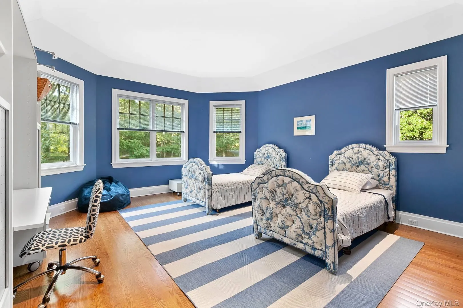 Bedroom featuring wood finished floors and multiple windows Bedroom featuring wood finished floors and multiple windows
