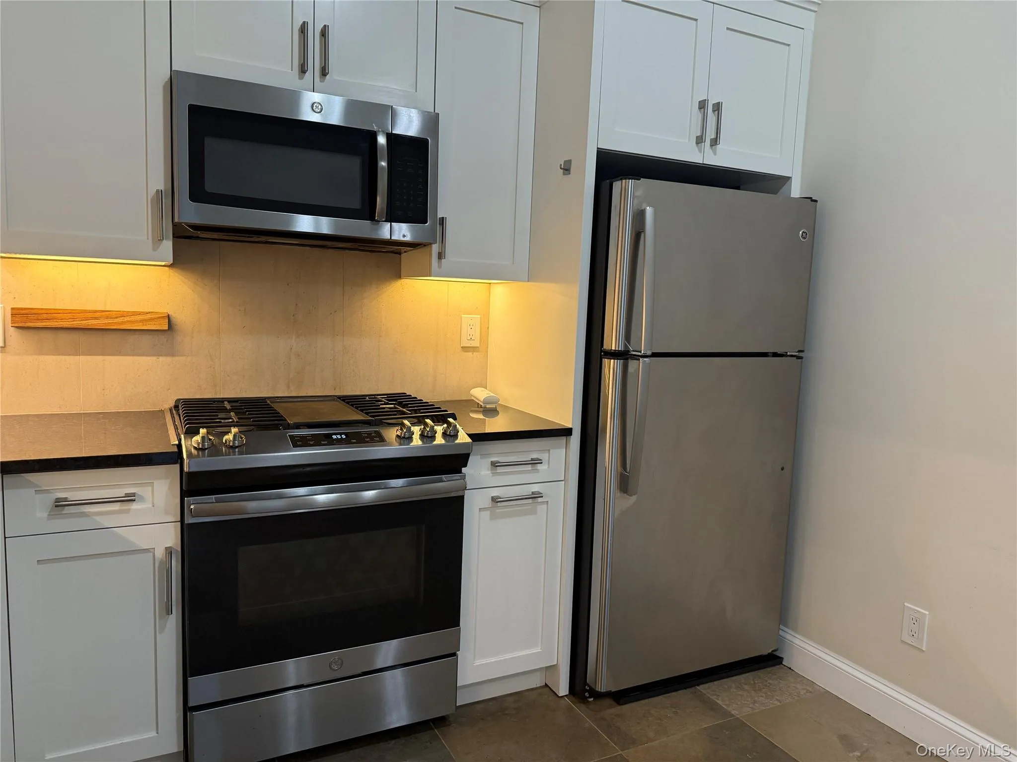 Kitchen with stainless steel appliances, white cabinets, and tasteful backsplash Kitchen with stainless steel appliances, white cabinets, and tasteful backsplash