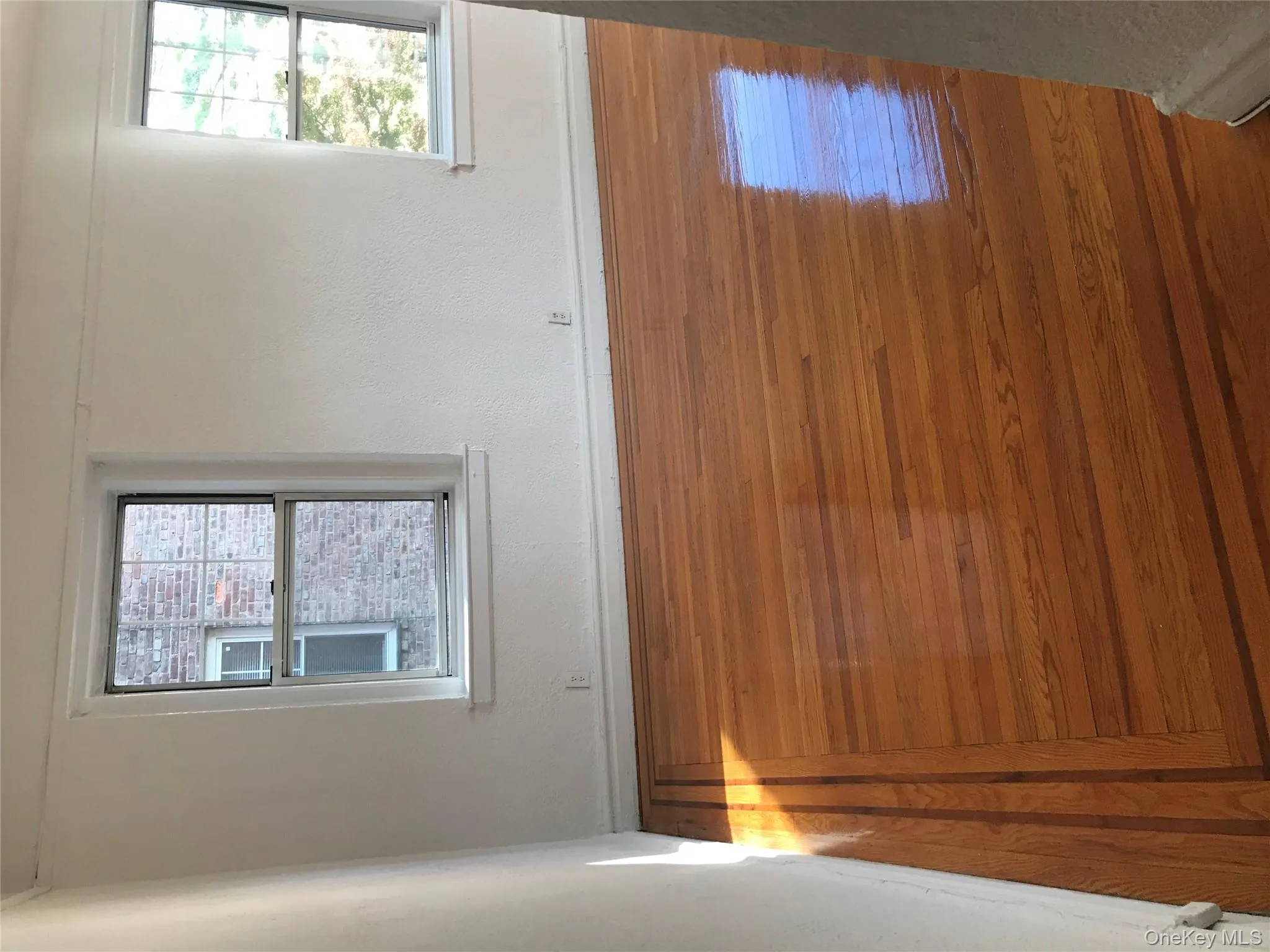 Unfurnished room featuring hardwood / wood-style flooring and baseboards Unfurnished room featuring hardwood / wood-style flooring and baseboards