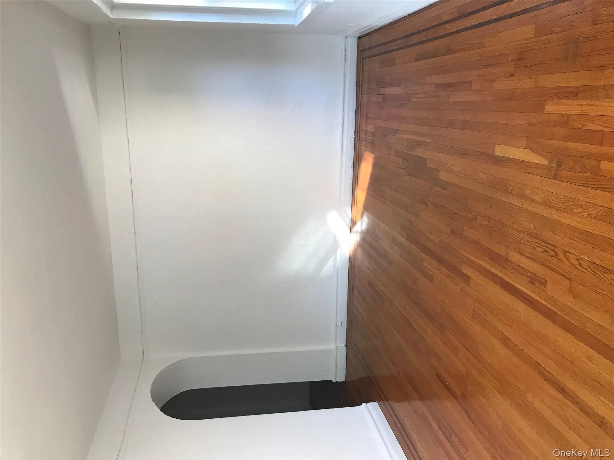 Spare room with arched walkways and wood finished floors Spare room with arched walkways and wood finished floors