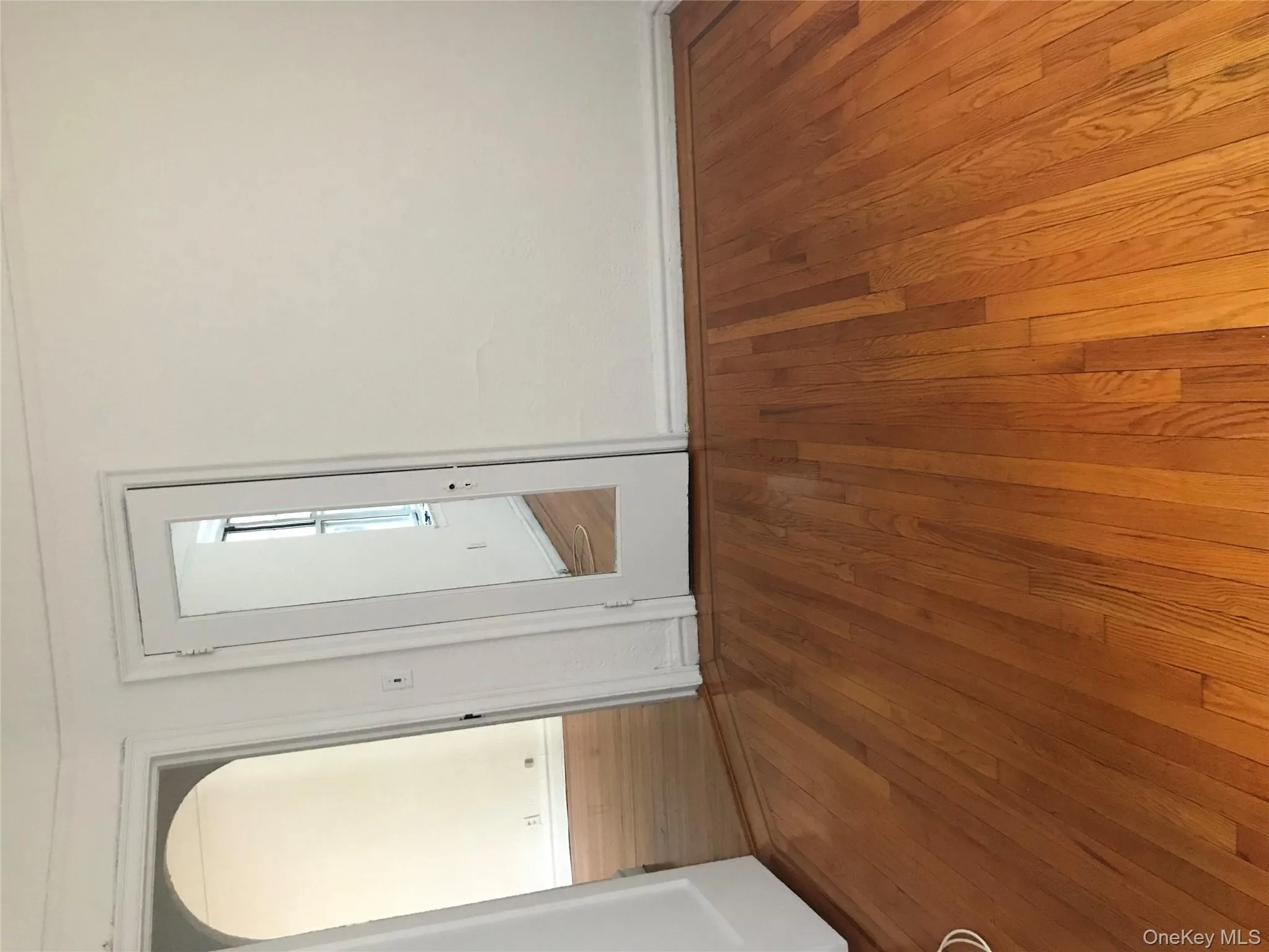 Unfurnished room featuring hardwood / wood-style flooring and arched walkways Unfurnished room featuring hardwood / wood-style flooring and arched walkways