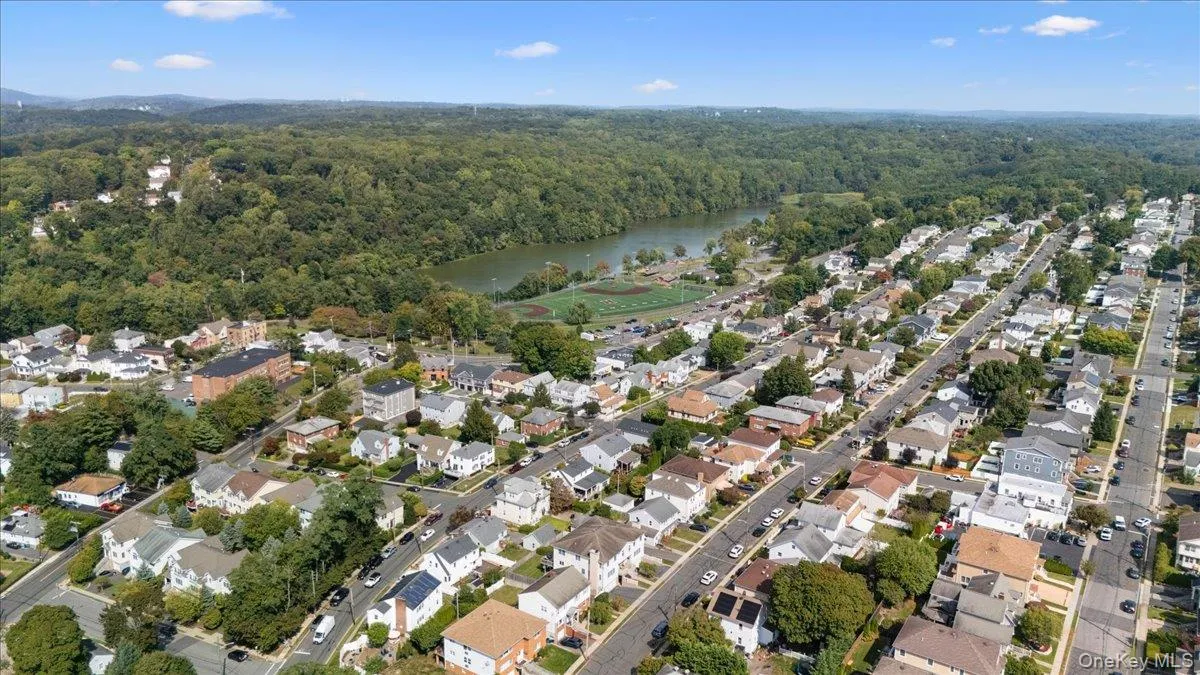 Aerial view of property and surrounding area with a large body of water and nearby suburban area Aerial view of property and surrounding area with a large body of water and nearby suburban area