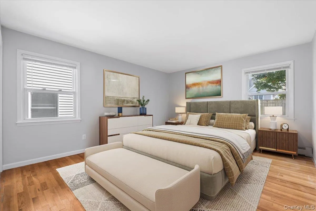 Bedroom featuring light wood-style floors and a baseboard radiator*Virtually Staged Bedroom featuring light wood-style floors and a baseboard radiator*Virtually Staged