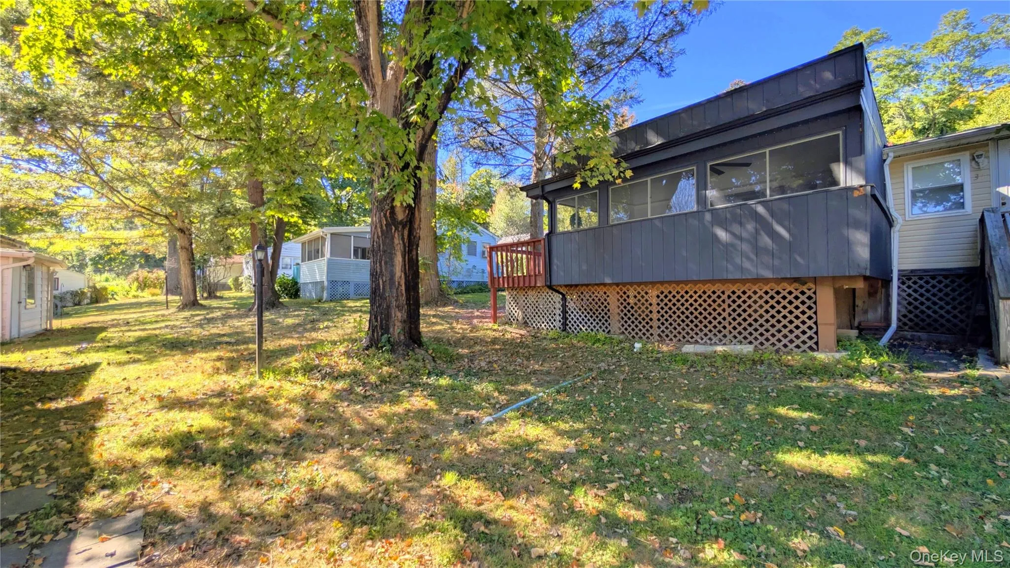 Rear view of house with a sunroom and a deck Rear view of house with a sunroom and a deck