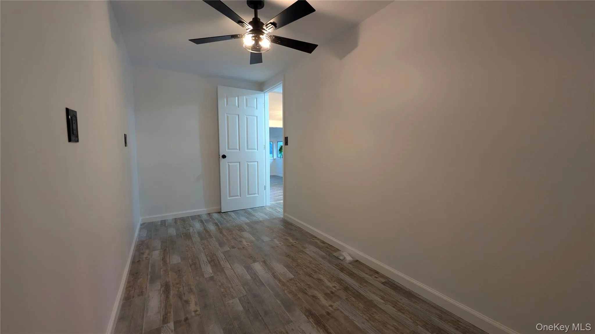 Hallway with wood finished floors and baseboards Hallway with wood finished floors and baseboards