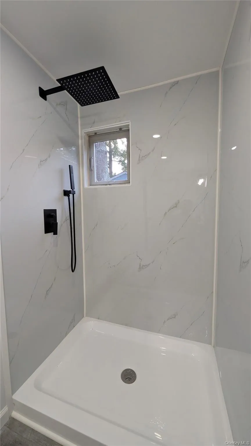 Full bath with a marble finish shower Full bath with a marble finish shower