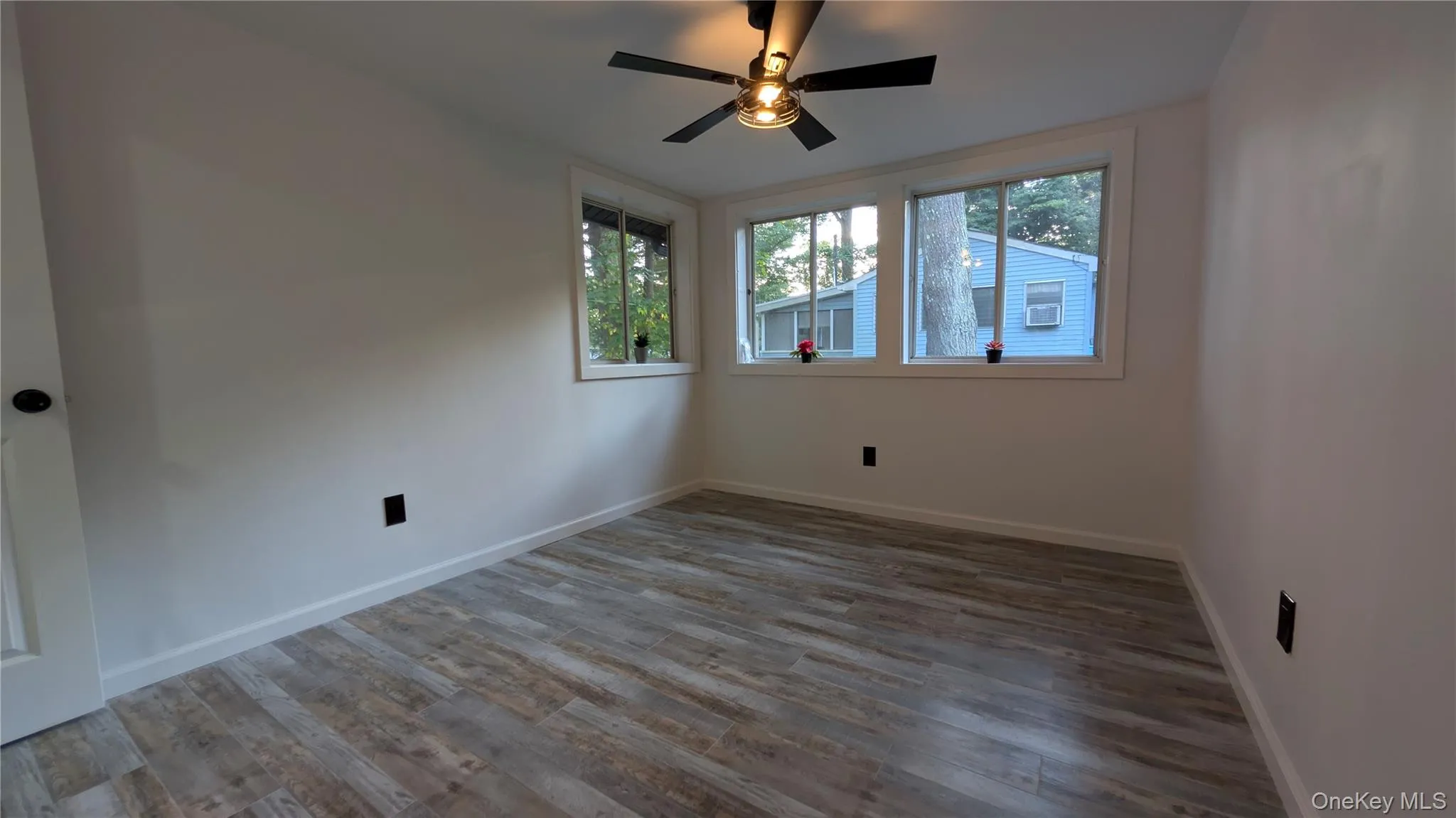 Spare room with dark wood-type flooring and a ceiling fan Spare room with dark wood-type flooring and a ceiling fan