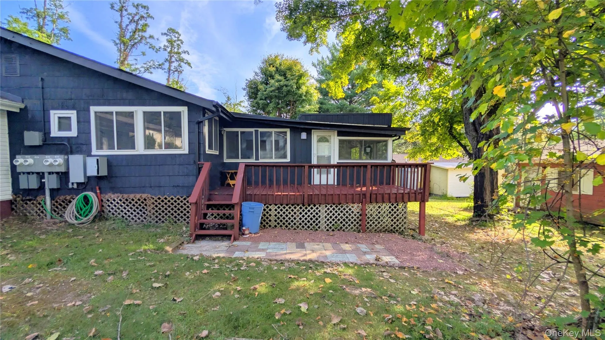 Back of property with a yard, a wooden deck, and an outbuilding Back of property with a yard, a wooden deck, and an outbuilding