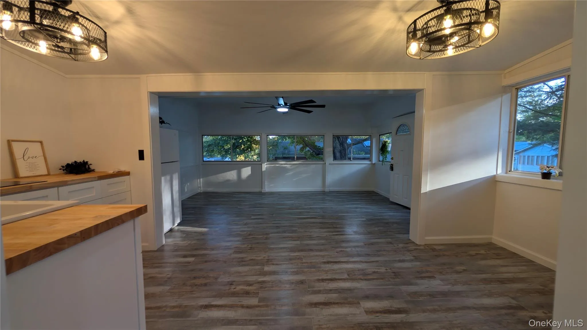 Unfurnished dining area featuring a chandelier, dark wood-style floors, and ceiling fan Unfurnished dining area featuring a chandelier, dark wood-style floors, and ceiling fan
