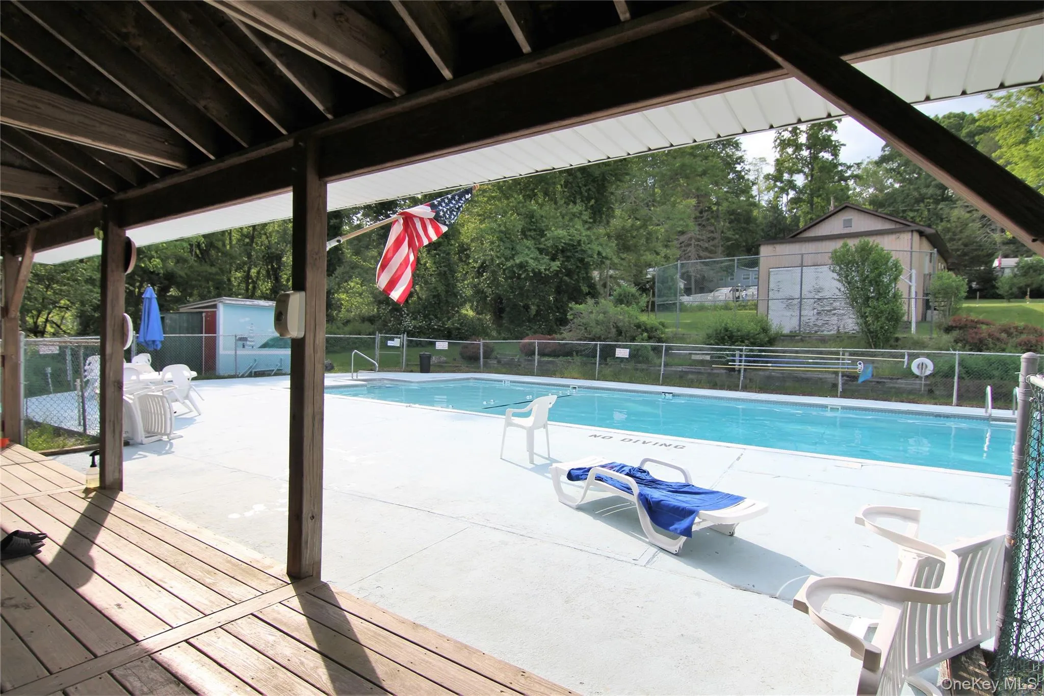 Community pool with a storage unit and a deck Community pool with a storage unit and a deck