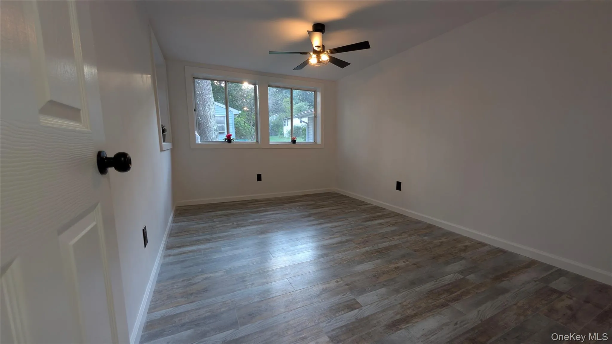 Empty room with wood finished floors and ceiling fan Empty room with wood finished floors and ceiling fan