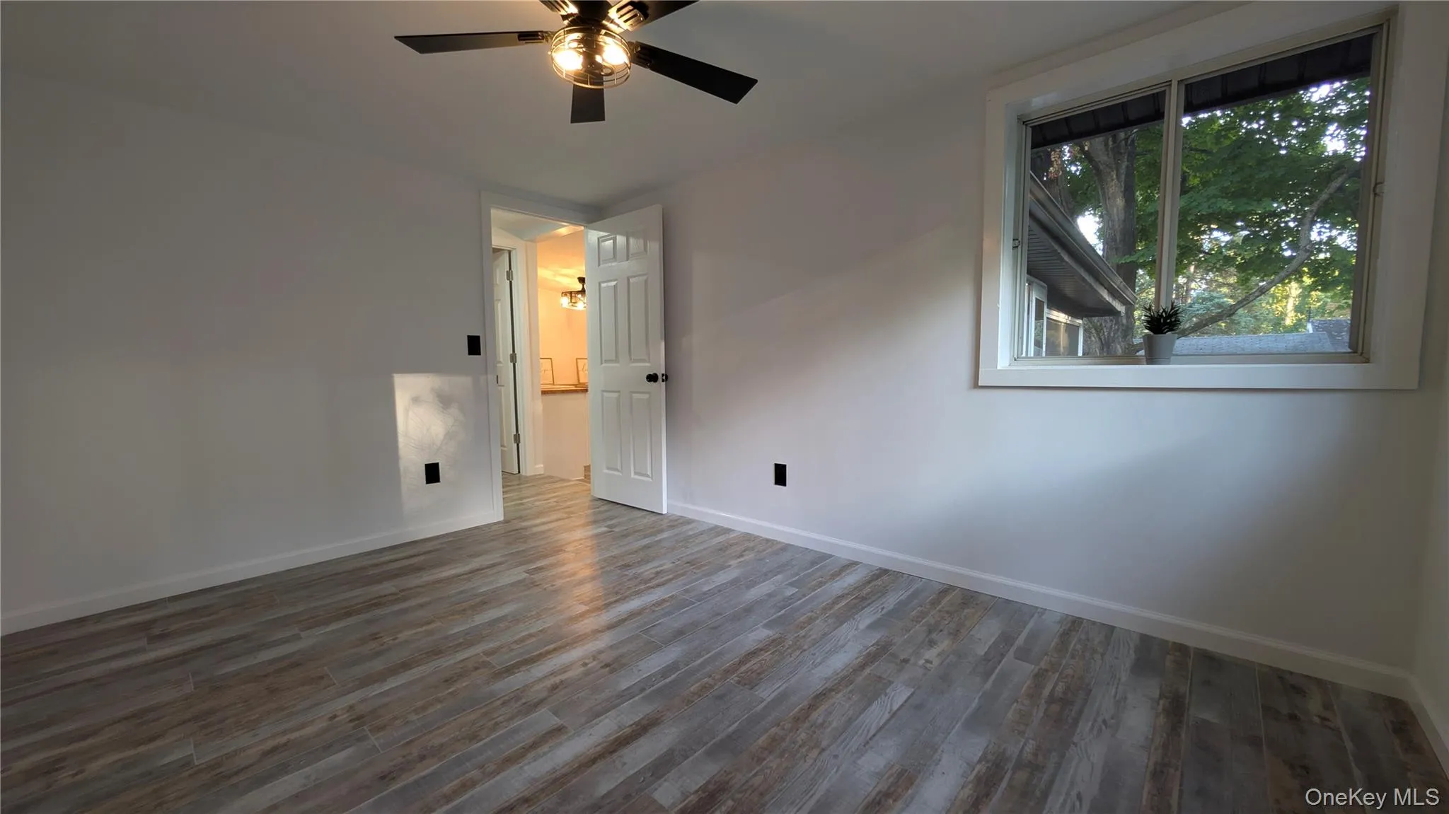Unfurnished bedroom with dark wood-type flooring and a ceiling fan Unfurnished bedroom with dark wood-type flooring and a ceiling fan