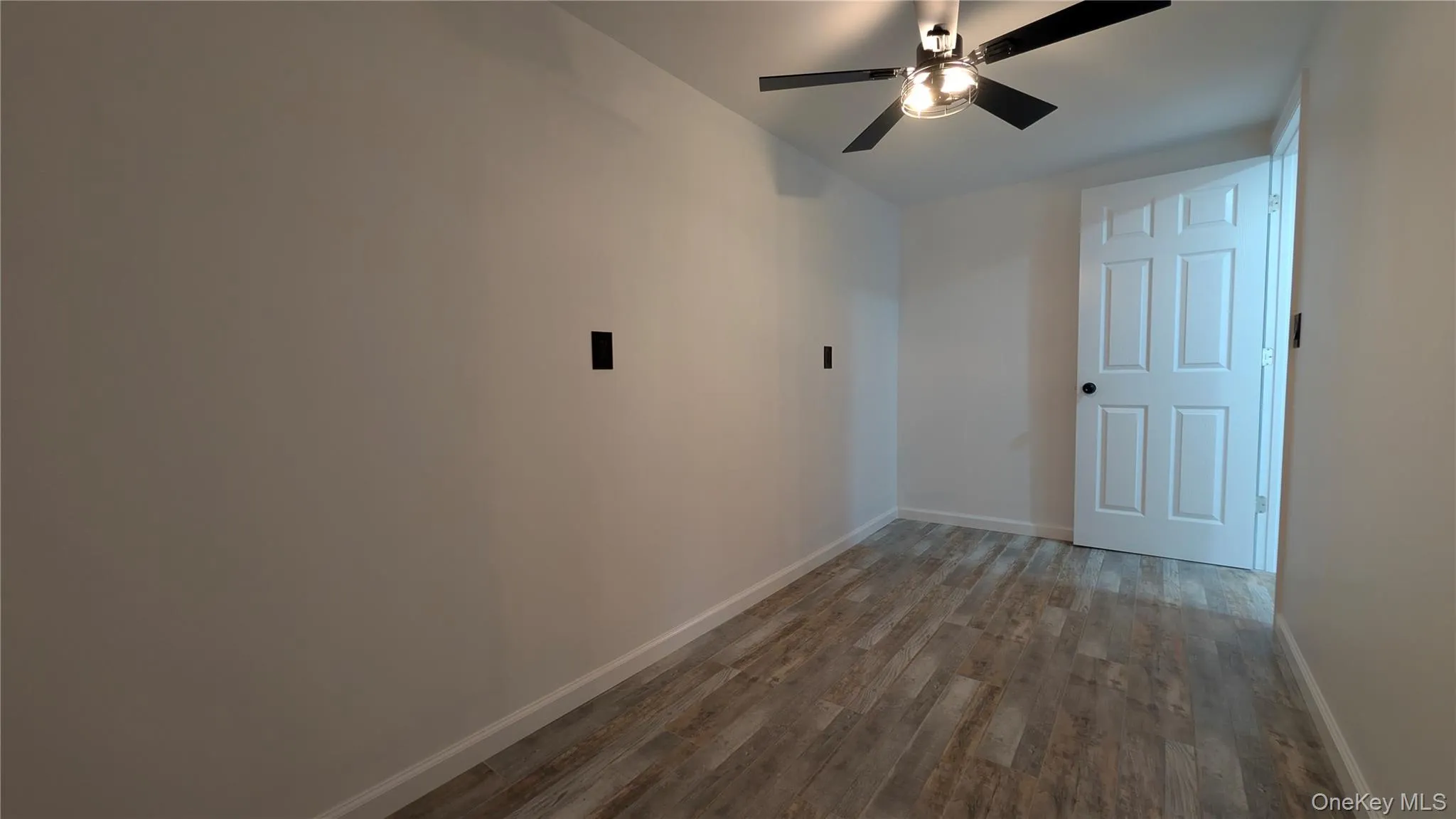 Additional living space featuring dark wood-type flooring and a ceiling fan Additional living space featuring dark wood-type flooring and a ceiling fan