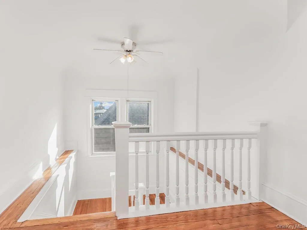 Staircase featuring wood finished floors and ceiling fan Staircase featuring wood finished floors and ceiling fan