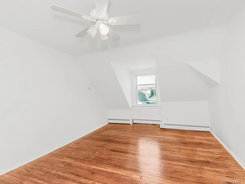 Additional living space with light wood finished floors, vaulted ceiling, and ceiling fan Additional living space with light wood finished floors, vaulted ceiling, and ceiling fan