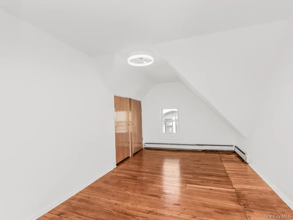 Bonus room featuring lofted ceiling, hardwood / wood-style flooring, and baseboard heating Bonus room featuring lofted ceiling, hardwood / wood-style flooring, and baseboard heating