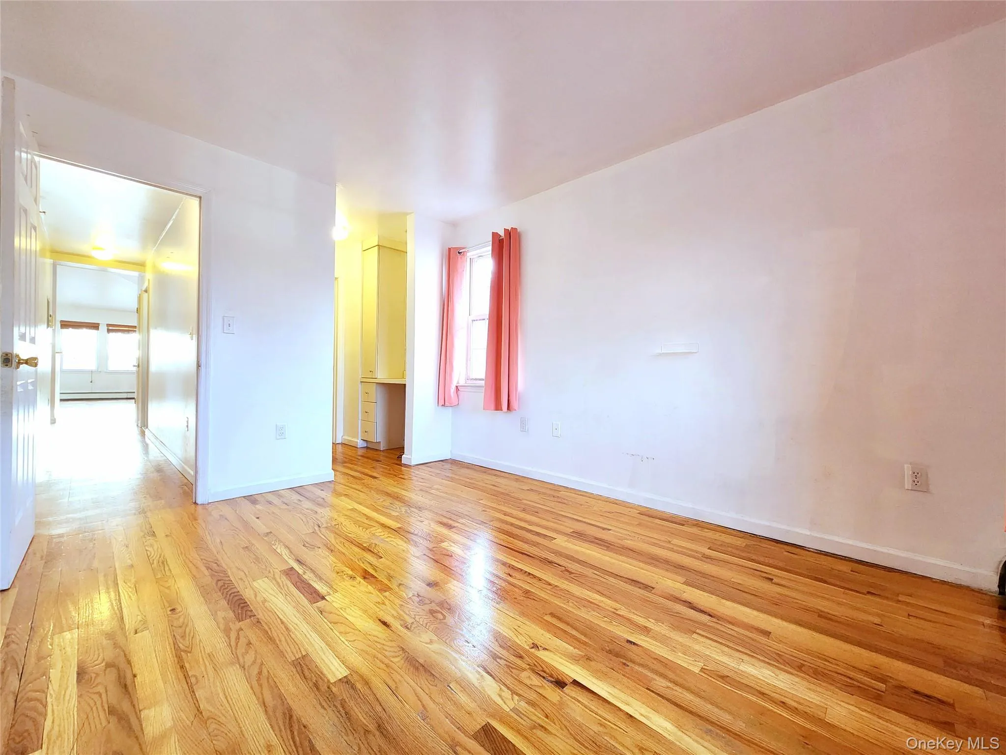 Unfurnished room featuring light wood-style flooring and a baseboard radiator Unfurnished room featuring light wood-style flooring and a baseboard radiator