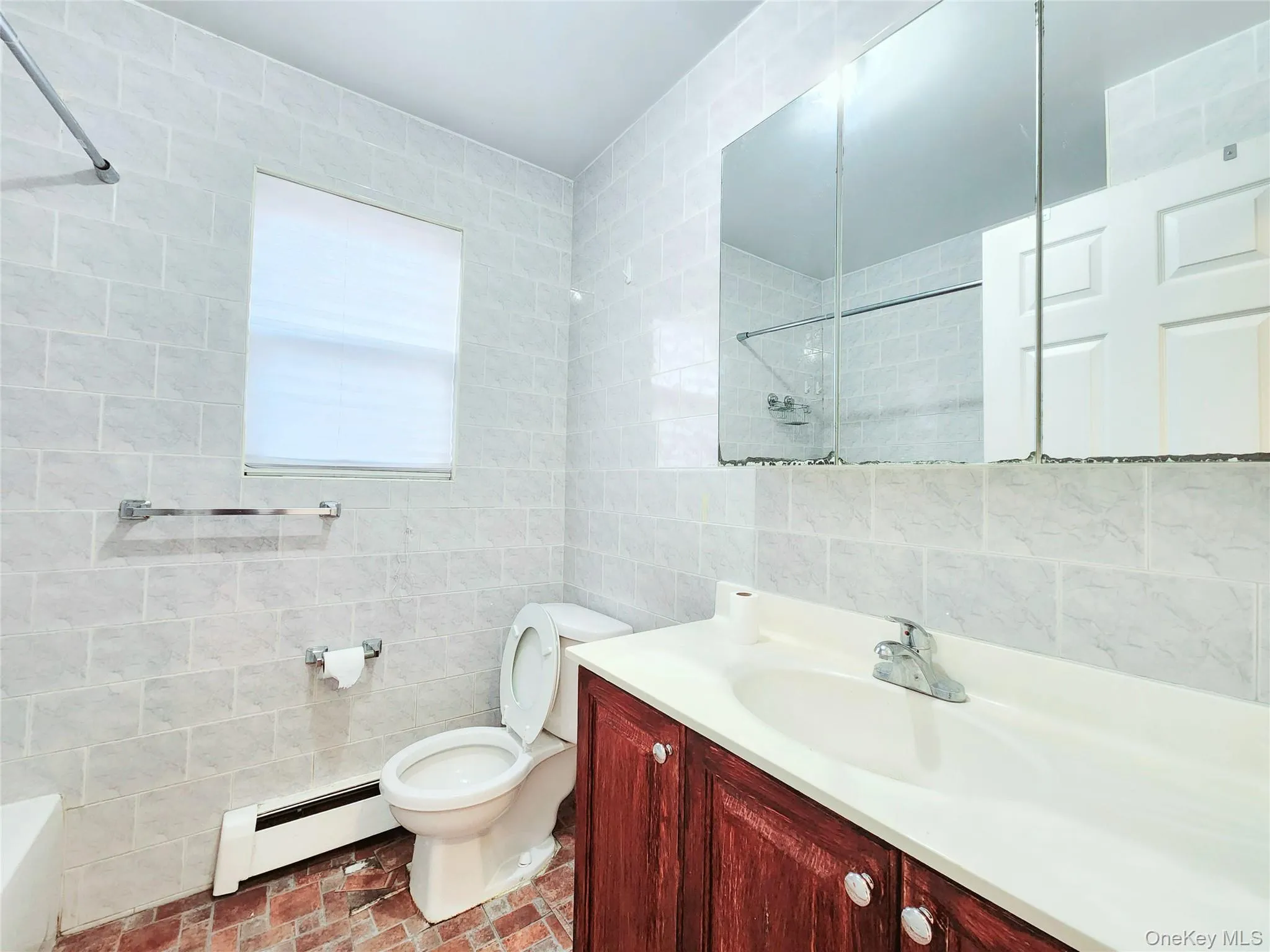 Bathroom featuring tile walls, a baseboard radiator, and vanity Bathroom featuring tile walls, a baseboard radiator, and vanity